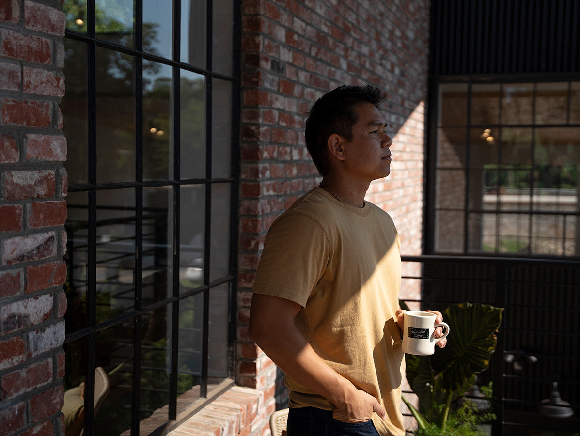 Man standing outside holding mug of coffee