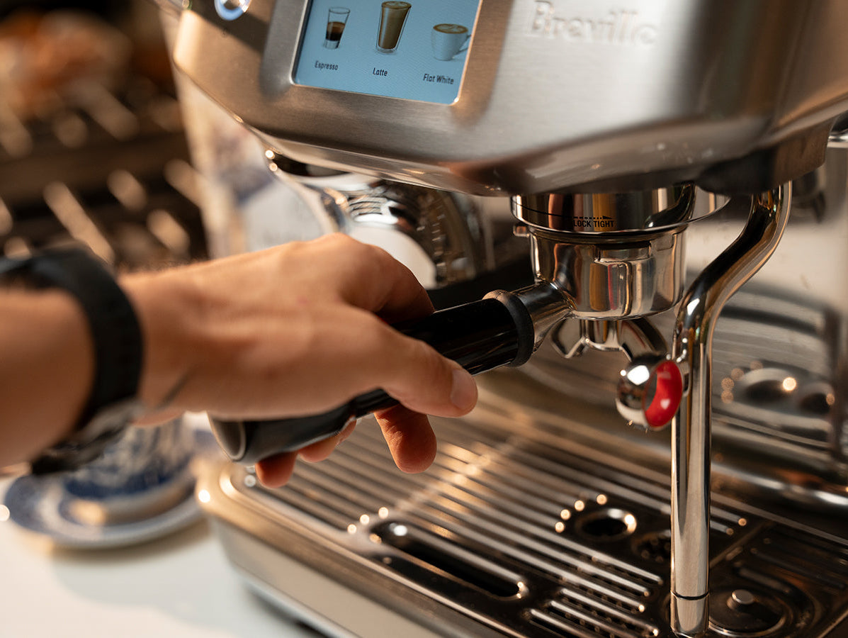 hand securing portafilter in espresso machine