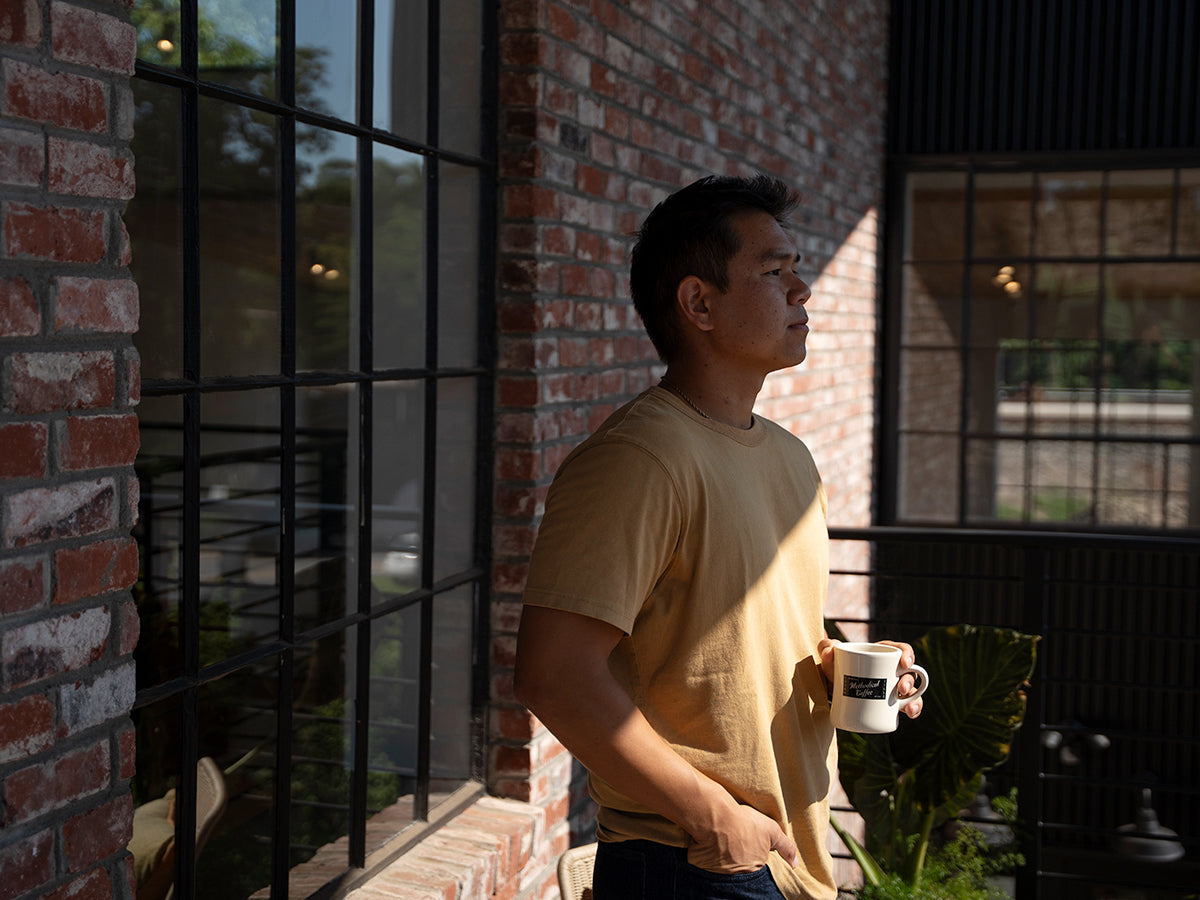 Man standing outside holding mug of coffee